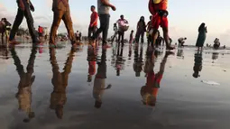 Orang-orang berjalan di Pantai Juhu, Mumbai, India, Selasa (24/8/2021). India mencatat penambahan 14.419 kasus positif COVID-19 pada 24 Agustus 2021. (AP Photo/Rafiq Maqbool)