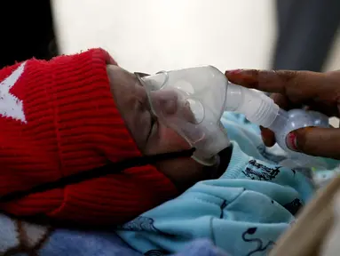 Dalam foto pada 7 November 2023 ini, seorang bayi berusia satu bulan bernapas dengan bantuan nebuliser di bangsal darurat rumah sakit anak-anak Chacha Nehru Bal Chikitsalaya yang dikelola oleh pemerintah di New Delhi, India. (Arun SANKAR / AFP)