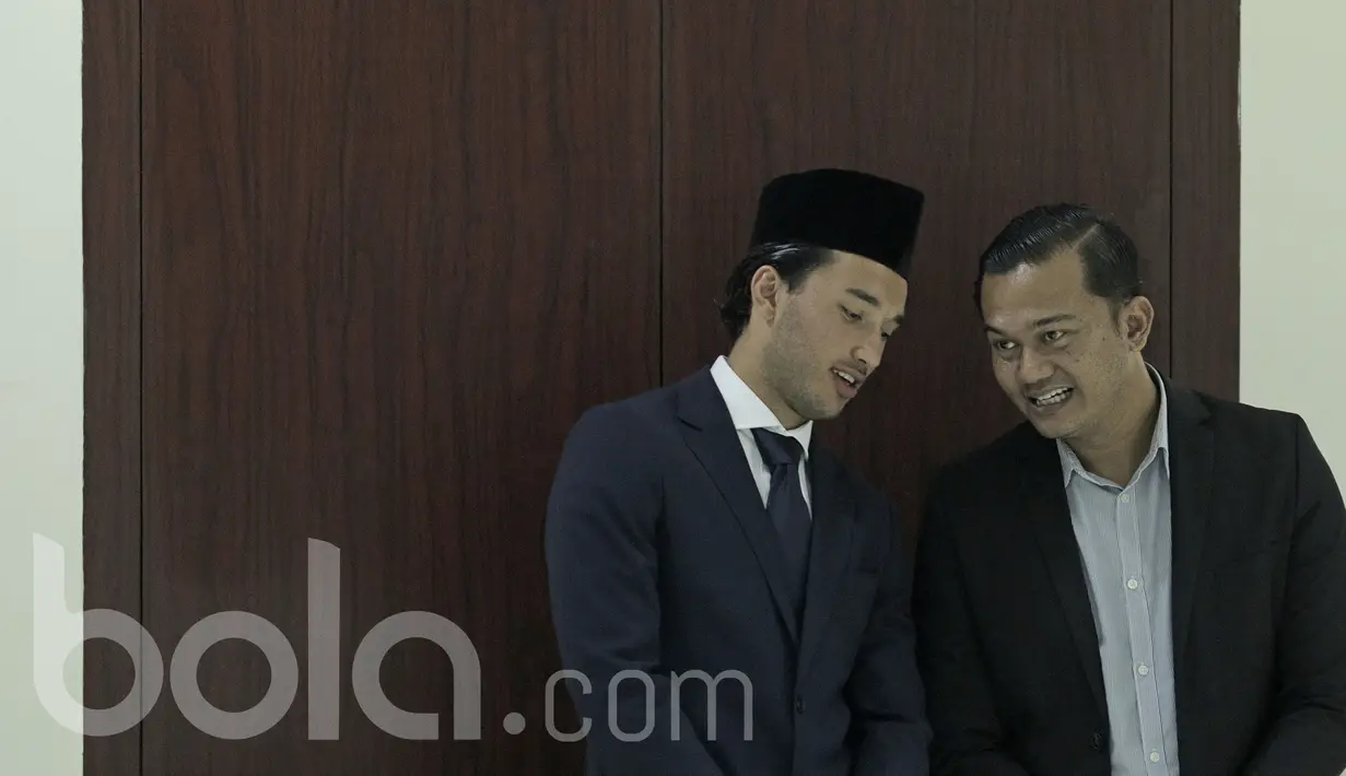 Ezra Walian pesepak bola naturalisasi asal Belanda berbincang dengan Wide Putera Ananda yang menjadi agennya saat menjalani proses menjadi WNI pada Kamis (18/5/2017) di Kanwil Menhukham, Jakarta. (Bola.com/Peksi Cahyo)