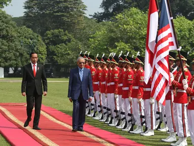 Presiden Jokowi dan PM Malaysia, Mahathir Mohamad memeriksa pasukan kehormatan saat kunjungan kenegaraan di Istana Bogor, Jumat (29/6). Kedua pemimpin akan menggelar pertemuan bilateral membahas berbagai isu dan kerjasama. (Liputan6.com/Angga Yuniar)