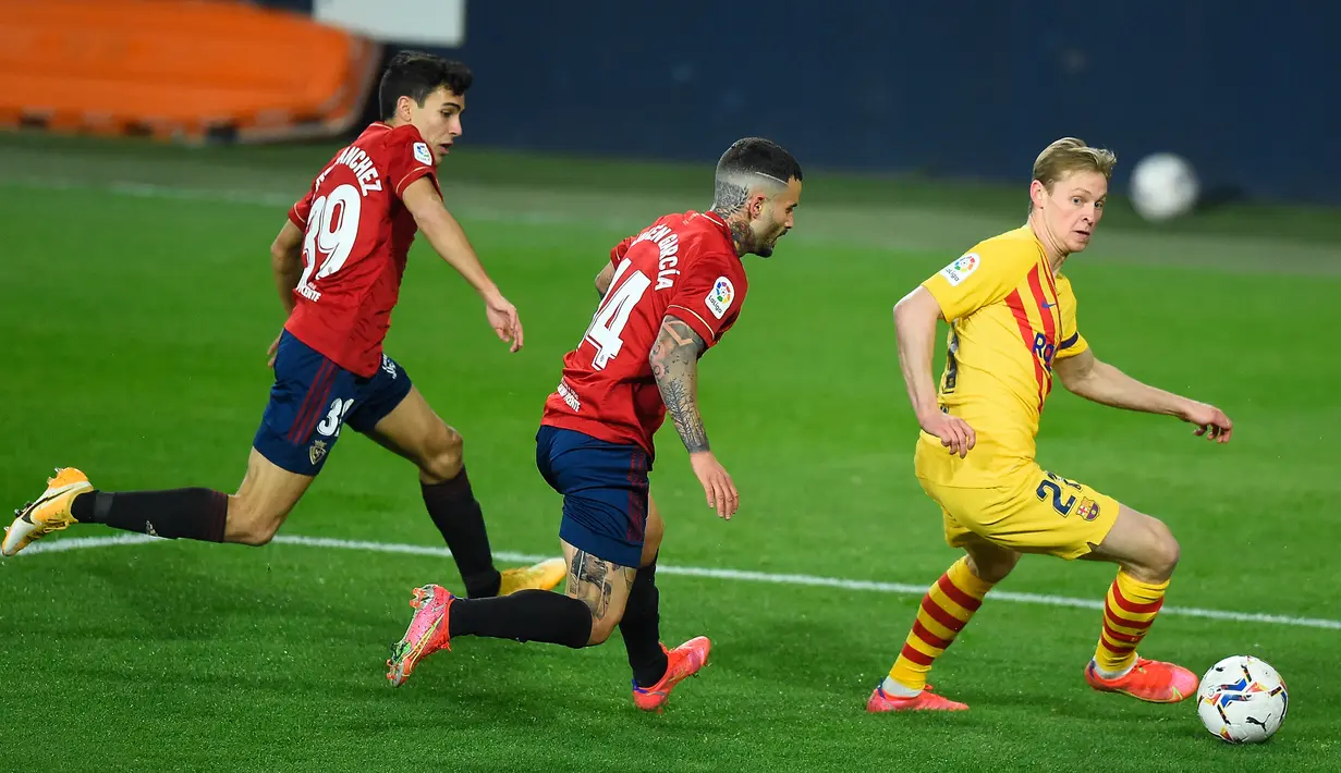 Gelandang Barcelona, Frenkie de Jong (kanan) menguasai bola dibayangi dua pemain Osasuna dalam laga lanjutan Liga Spanyol 2020/21 pekan ke-26 di El Sadar Stadium, Pamplona, Sabtu (6/3/2021). Barcelona menang 2-0 atas Osasuna. (AFP/Ander Gillenea)