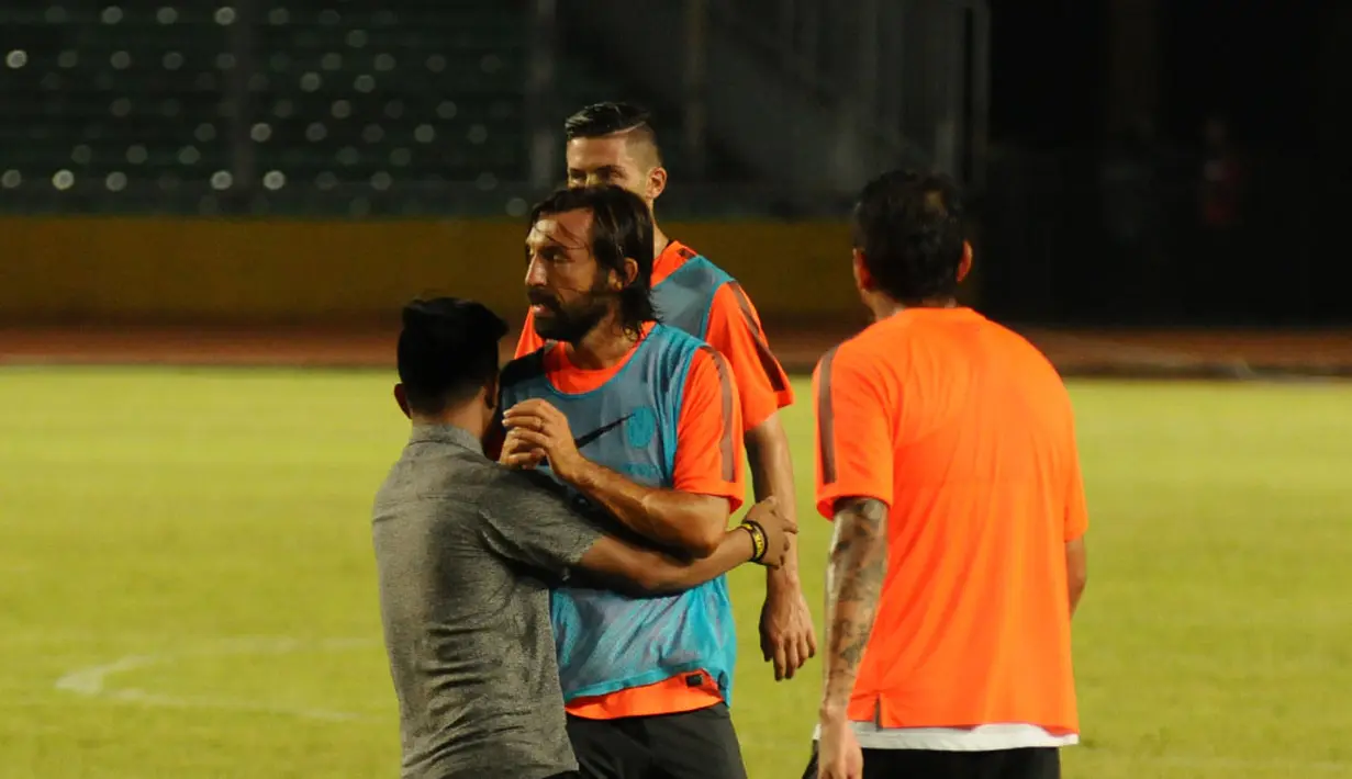 Gelandang Juventus, Andrea Pirlo, tidak bereaksi saat dipeluk salah satu penggemarnya di Stadion GBK, Jakarta, (5/8/2014). (Liputan6.com/Helmi Fithriansyah)  