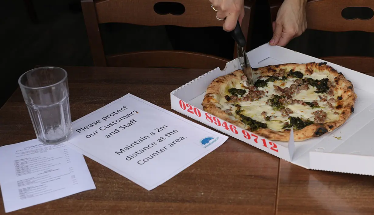 Pesan pengingat untuk menjaga jarak sosial terlihat di sebuah gerai di London, Inggris, Minggu (17/5/2020). Beberapa restoran, kafe, dan toko katering di Inggris secara bertahap kembali buka setelah pemerintah melonggarkan kebijakan lockdown akibat virus corona COVID-19. (Xinhua/Tim Ireland)