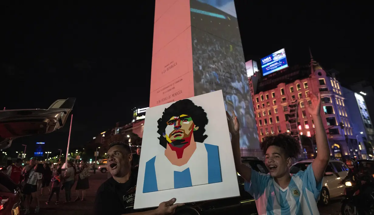 Seorang suporter memegang poster Diego Maradona untuk mendukung timnas Argentina sehari menjelang final Piala Dunia 2022, di Buenos Aires, Argentina, Sabtu, 17 Desember 2022. Argentina akan melawan Prancis pada babak final di Stadion Lusail Iconic, Minggu (18/12). (AP Photo/Rodrigo Abd )