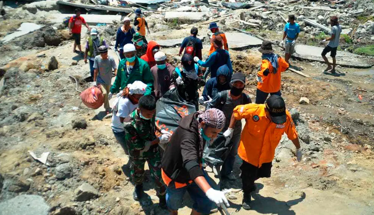 Tim penyelamat membawa tubuh korban setelah gempa dan tsunami menghantam Palu, Sulawesi Tengah, Senin (1/10). Sebanyak 18 negara menawarkan bantuan untuk bencana gempa dan tsunami Palu-Donggala. (AP Photo/Rifki)