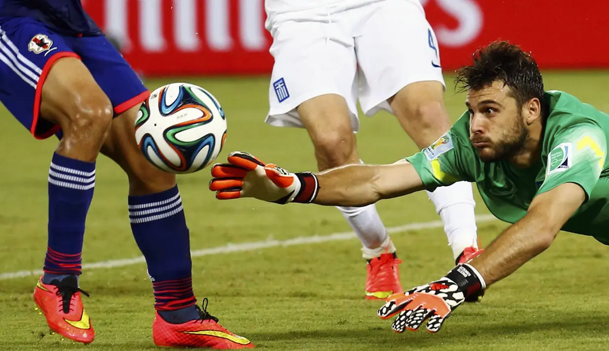 Penjaga gawang Yunani, Orestis Karnezis, berusaha merebut bola dari kaki pemain Jepang saat berlaga di babak penyisihan Piala Dunia 2014 Grup C di Stadion Dunas, Natal, Brasil, (20/6/2014). (REUTERS/Kai Pfaffenbach)