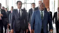 Kedatangan Jokowi di APEC Haus disambut tarian 'Hiri Moale'. Seusai penyambutan, PM Marape bersama Jokowi kemudian berjalan naik ke lantai dua APEC Haus untuk menuju ruang pelaksanaan tête-à-tête. (ANDREW KUTAN/AFP)