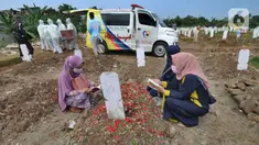 Warga berziarah dengan latar belakang pemakaman korban Covid-19 di TPU Srengseng Sawah 2, Jagakarsa, Jakarta, Senin (17/5/2021). Hari ini seluruh TPU di wilayah DKI dibuka untuk umum dengan menerapkan protokol kesehatan seperti pembatasan pengunjung dan waktu berziarah. (merdeka.com/Arie Basuki)