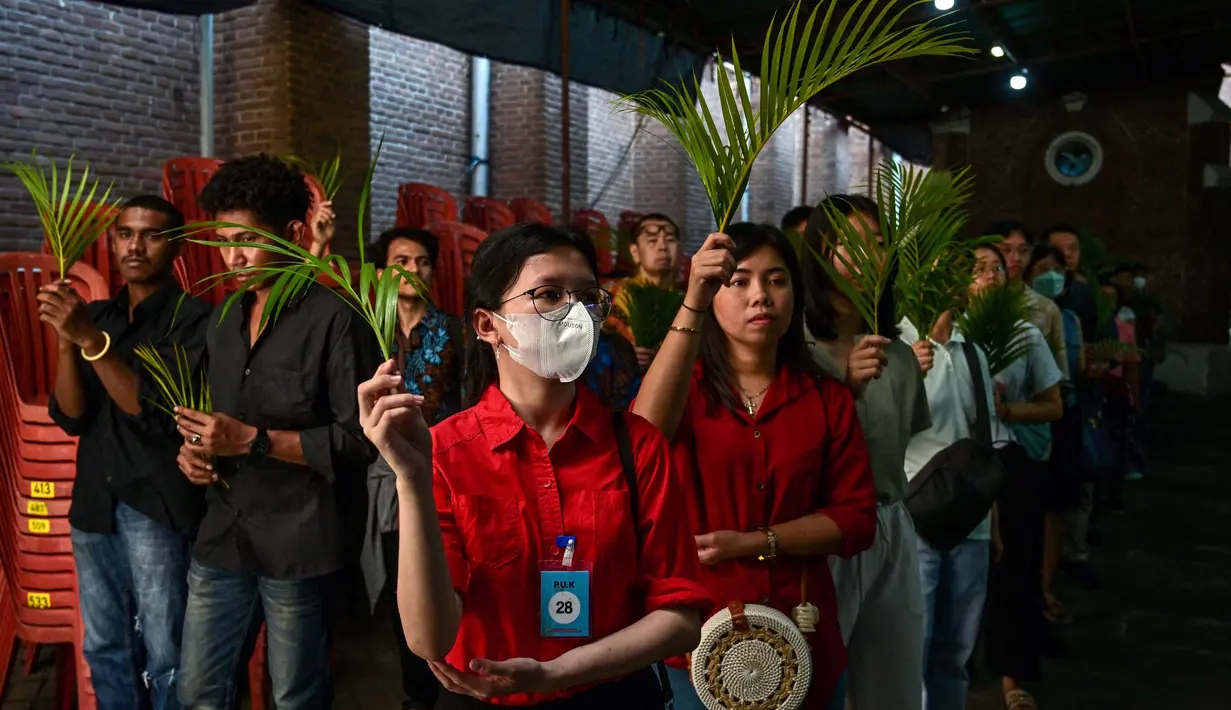 Daun palma yang dilambaikan bermakna sebagai bentuk pujian kemuliaan atas kemenangan Yesus Kristus yang telah bangkit mengalahkan kematian. (JUNI KRISWANTO/AFP)