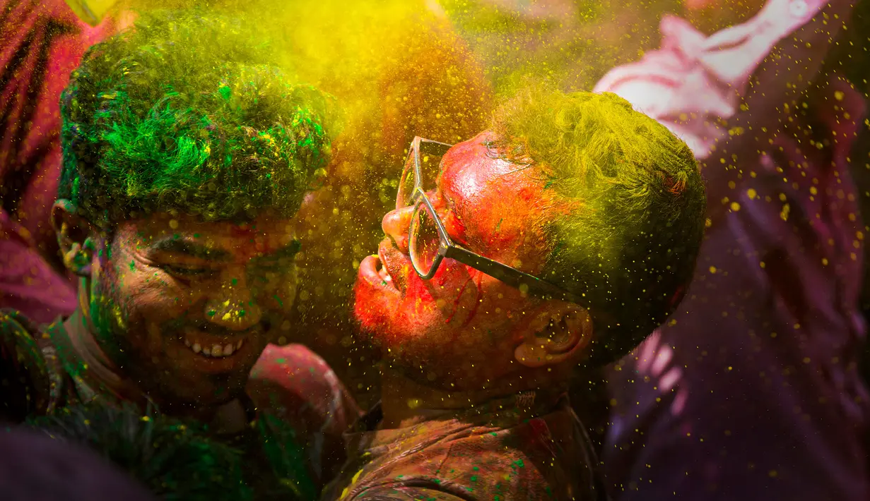 Orang-orang menari dan melempar bubuk berwarna saat Festival Holi di Gauhati, India, Selasa (10/3/2020). Festival Holi menandai datangnya musim semi di India. (AP Photo/Anupam Nath)