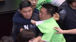Anggota parlemen dari Partai Progresif Demokratik (DPP) terlibat bentrok dengan Partai Nasionalis Tiongkok atau yang dikenal dengan Kuomintang (KMT) saat melakukan protes di Parlemen di Taipei (20/4). (AFP Photo/Sam Yeh)