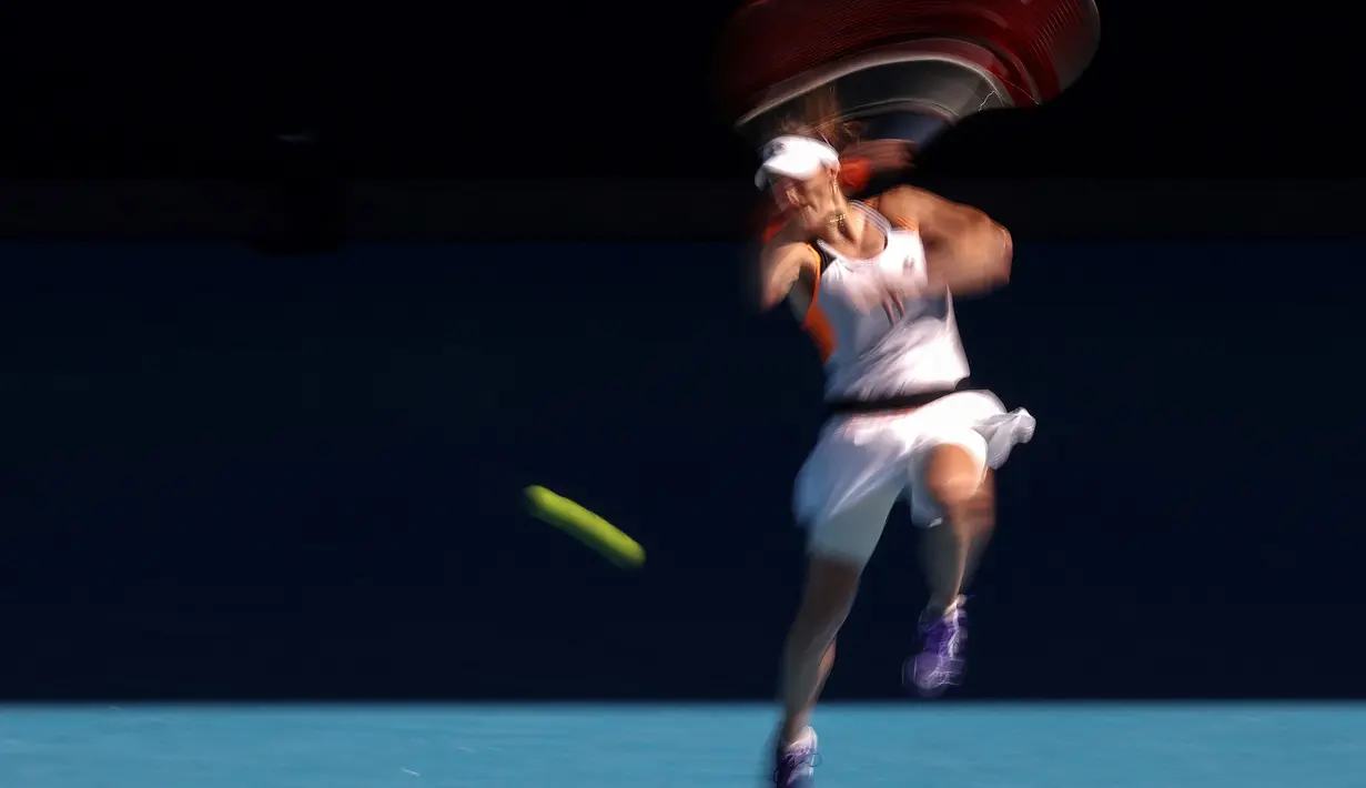 Petenis Prancis Alize Cornet, menegmbalikan bola saat melawan petenis Rumania, Simona Halep dalam pertandingan tunggal putri mereka pada hari kedelapan turnamen tenis Australia Terbuka di Melbourne pada 24 Januari 2022.
(AFP/Martin Keep)