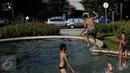 Anak-anak  berenang di kolam air mancur di kawasan Jalan Diponogoro, Jakarta, Jumat (31/7/2015). Minimnya lahan bermain di Ibukota, membuat mereka memanfaatkan kolam air mancur sebagai tempat berenang. (Liputan6/Johan Tallo)