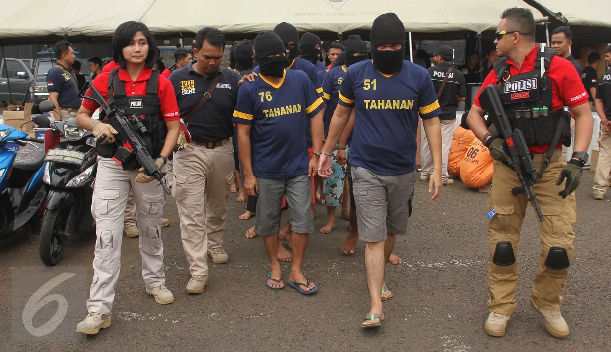 Polwan cantik, Bripda Suci Amelia mengawal sejumlah tersangka usai rilis hasil pengungkapan Operasi Pekat di Polda Metro Jaya, Jakarta, Jumat (3/6). Bripda Suci adalah salah satu dari pasukan Jaguar, tim elite Polres Depok. (Liputan6.com/Gempur M Surya)
