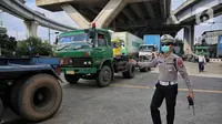 Polisi Lalu Lintas dan Dinas Perhubungan Daerah Khusus Jakarta melakukan pengaturan keluar masuk kendaraan truk kontainer di area Perempatan Pos IX Pelabuhan Tanjung Priok, Jakarta Utara, Jumat (18/4/2025). (Liputan6.com/Angga Yuniar)