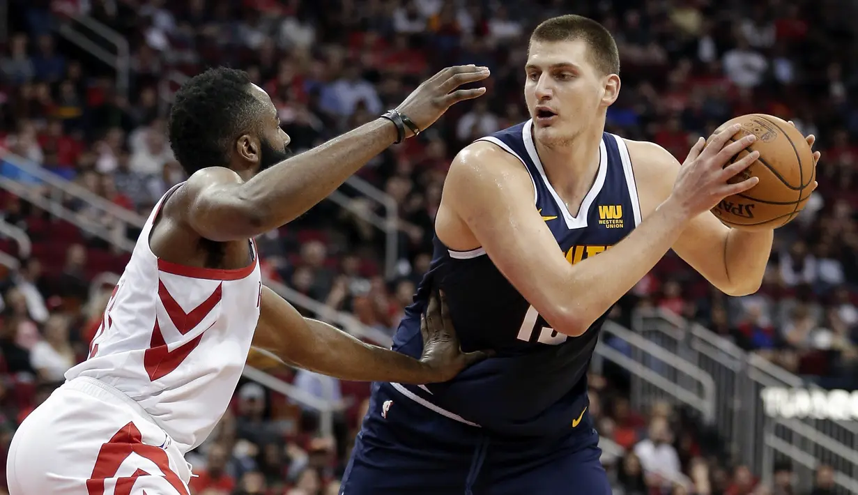 Pebasket Houston Rockets, James Harden, berusaha merebut bola dengan pemain Denver Nuggets, Nikola Jokic, pada laga NBA di Toyota Center, Selasa (8/1). Houston Rockets menang 125-113 atas Denver Nuggets. (AP/Michael Wyke)