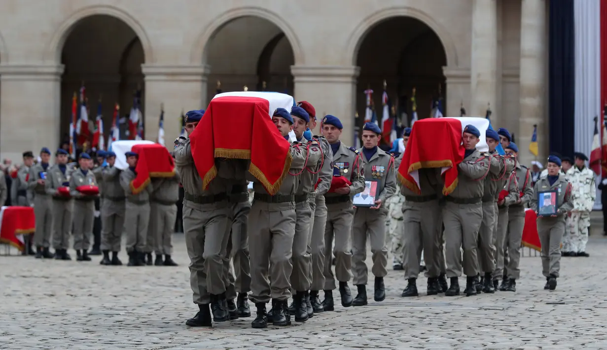 Prajurit  membawa peti jenazah tentara Prancis yang tewas dalam kecelakaan helikopter di Mali, Paris, Senin (2/12/2019). Sebanyak 13 tentara tewas setelah dua helikopter yang ditumpangi bertabrakan dalam operasi melawan miltan di Mali. (AP Photo/Thibault Camus,Pool)