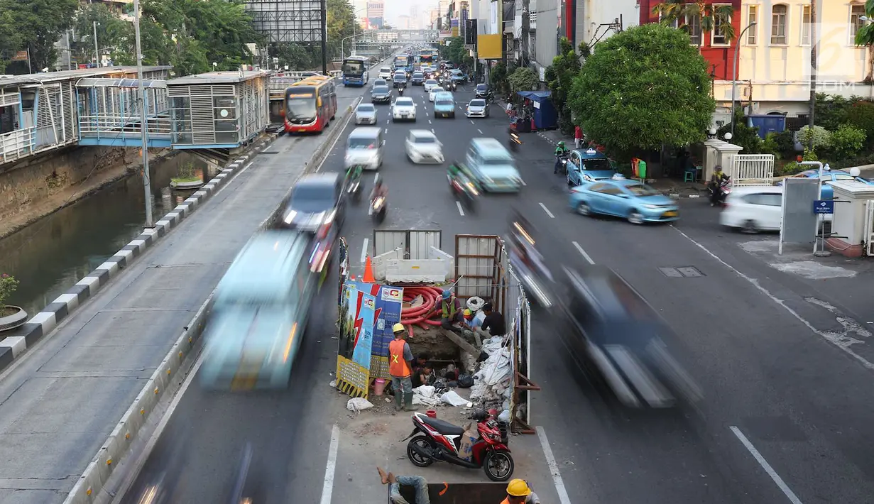 Kendaraan melintas di samping pengerjaan galian kabel bawah tanah di tengah Jalan Gajah Mada, Jakarta, Senin (11/6). Proyek yang dicanangkan Mei 2015 tersebut merupakan bagian dari proyek pembangkit listrik 35.000 MW. (Liputan6.com/Immanuel Antonius)