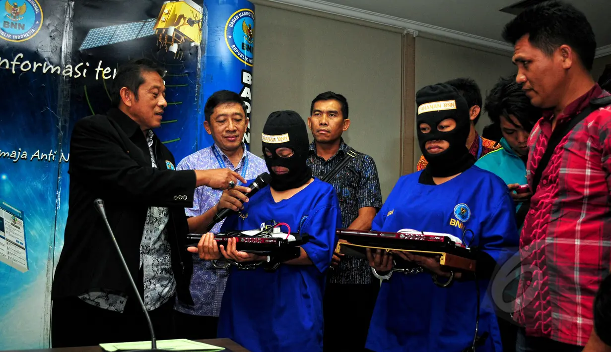 Dua wanita kurir narkoba saat memegang barang bukti, di kantor BNN, Jakarta, Selasa (19/5). Keduanya ditangkap aparat BNN dengan barang bukti 12,29 kilogram sabu. (Liputan6.com/Yoppy Renato)