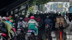 Pengendara sepeda motor memenuhi ruas jalan ketika berteduh di kolong Fly Over Cawang, Jakarta, Selasa (17/12/2019). Perilaku tersebut selain menimbulkan ketidaknyamanan pengguna jalan lainnya, juga memicu kemacetan. (Liputan6.com/Faizal Fanani)