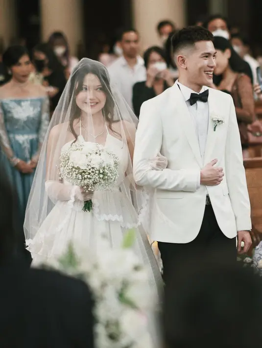 Gaun pengantin tersebut berpotongan kerah halter trendi yang memiliki siluet ball gown klasik. [@julianjacs]