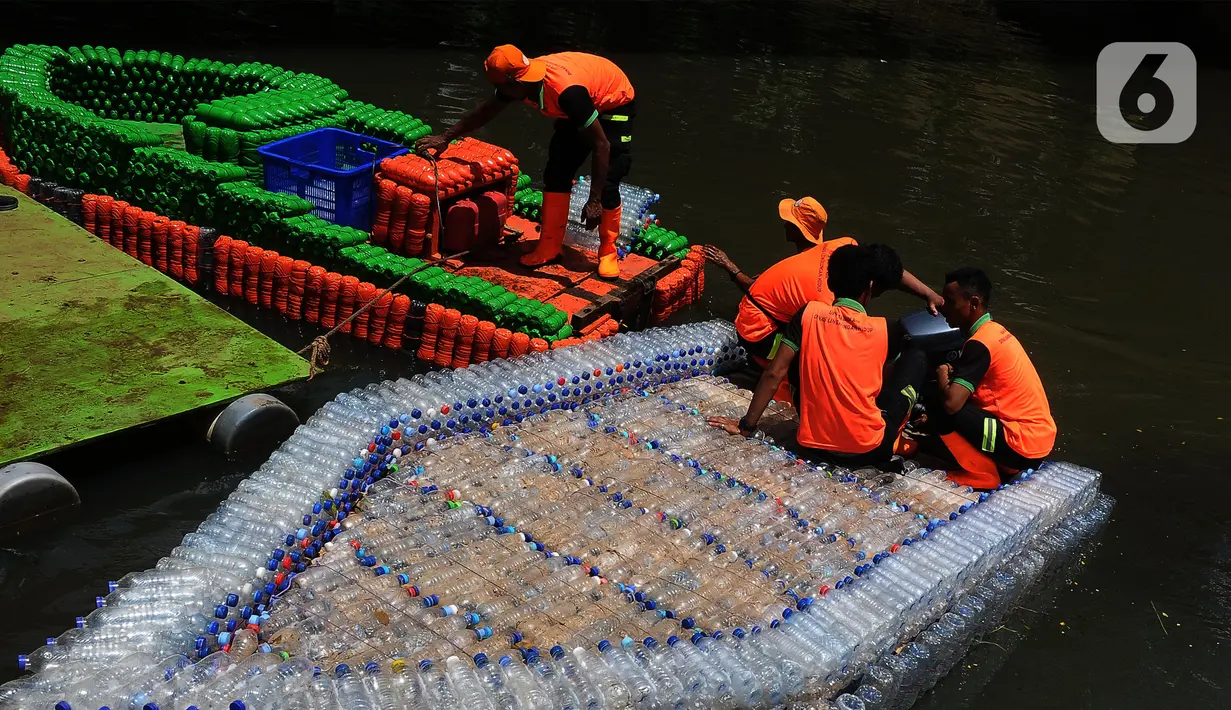 Petugas UPK Badan Air Provinsi DKI Jakarta melakukan ujicoba ketahanan dan kesimbangan perahu yang terbuat dari botol plastik bekas di aliran Kanal Banjir Timur (KBT), Jakarta, Selasa (5/3/2024). (merdeka.com/Imam Buhori)