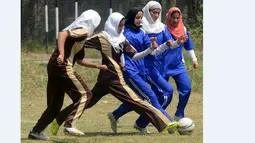 Siswa putri di Kashmir bermain sepakbola dalam sebuah turnamen di Srinagar, India. (10/9/2015). (AFP Photo/Tauseef Mustafa)