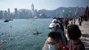 Penonton menyaksikan perlombaan renang melintasi Pelabuhan Victoria Hong Kong dari daerah Tsim Sha Tsui, Minggu (12/12/2021). Lomba renang tahunan itu diadakan untuk pertama kalinya dalam tiga tahun, setelah dibatalkan karena demonstrasi besar-besaran dan kemudian pandemi COVID-19. (Bertha WANG/AFP)