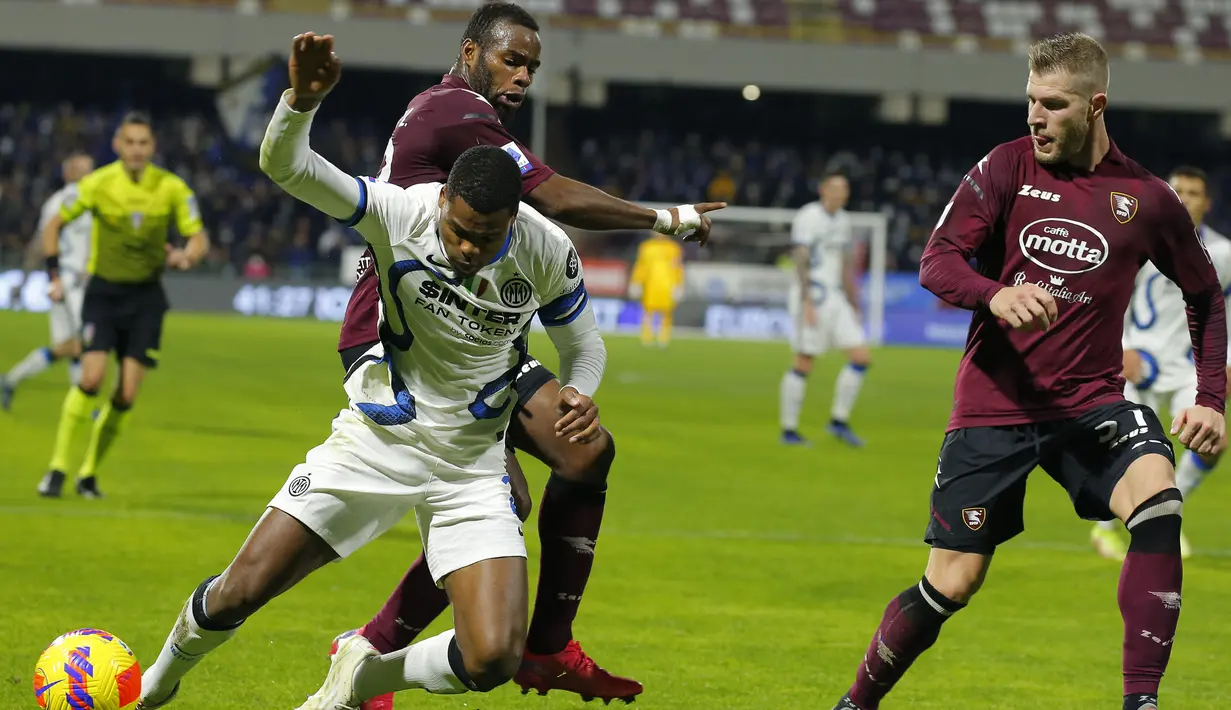 Gelandang Salernitana Lassana Coulibaly (Kiri Belakang) menjegal bek Inter Milan Denzel Dumfries pada giornata ke-18 Liga Italia di Stadion Arechi, Salerno, Sabtu (18/12/2021) dini hari WIB. Inter Milan pesta gol 5-0 di kandang Salernitana. (Carlo Hermann / AFP)