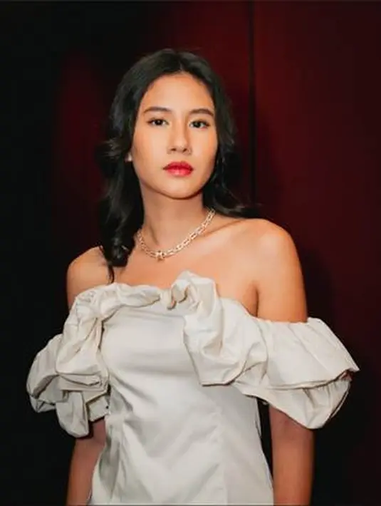 Mendampingi Angga Yunanda, Shenina Cinnamon juga tampil memukau. Ia memilih mengenakan off-the-shoulder mini dress berwarna putih. Dress ini memiliki detail serut di sepanjang lengan. [Foto: Document/BVLGARI]