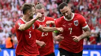 Penyerang Austria, Marko Arnautovic merayakan dengan rekan setimnya setelah mencetak gol ketiga timnya selama pertandingan sepak bola Euro 2024 Grup D melawan Polandia di Olympiastadion, Berlin, Jerman pada 21 Juni 2024. (JOHN MACDOUGALL/AFP)