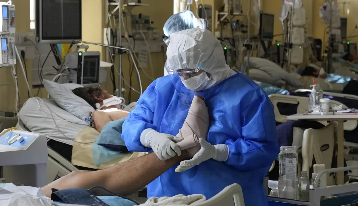Pekerja medis membalut kaki pasien di ICU untuk pasien COVID-19 di Rumah Sakit Umum di La Paz, Rabu (23/6/2021). Menurut otoritas kesehatan, Bolivia mengalami gelombang ketiga pandemi COVID-19 dengan total kasus positif corona mencapai 424 ribu orang dan 16.243 kematian. (AP Photo/Juan Karita)