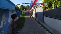 Bendera merah putih sepanjang 1.300 meter dibentangkan mengelilingi kampung di Surabaya, Jawa Timur. (Foto: Liputan6.com/Dian Kurniawan)