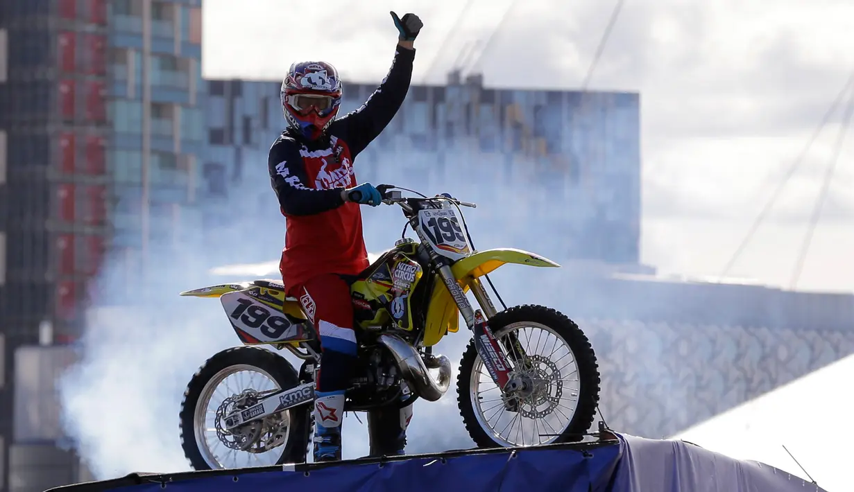 Travis Pastrana berpose di atas sepeda motornya setelah melakukan backflip di dekat Sungai Thames, London, Kamis (5/10). Aksi ini merupakan aksi backflip pertama setelah 11 tahun lalu seorang stunt rider lain gagal melakukannya. (AP Photo/Alastair Grant)