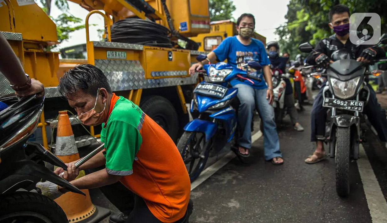 Petugas mengecek emisi gas buang kendaraan bermotor di Jakarta, Rabu (6/1/2021). Pengecekan yang diselenggarakan Dinas Perhubungan dan Kepolisian tersebut bertujuan untuk mengurangi polusi udara dari emisi gas buang kotor. (Liputan6.com/Faizal Fanani)