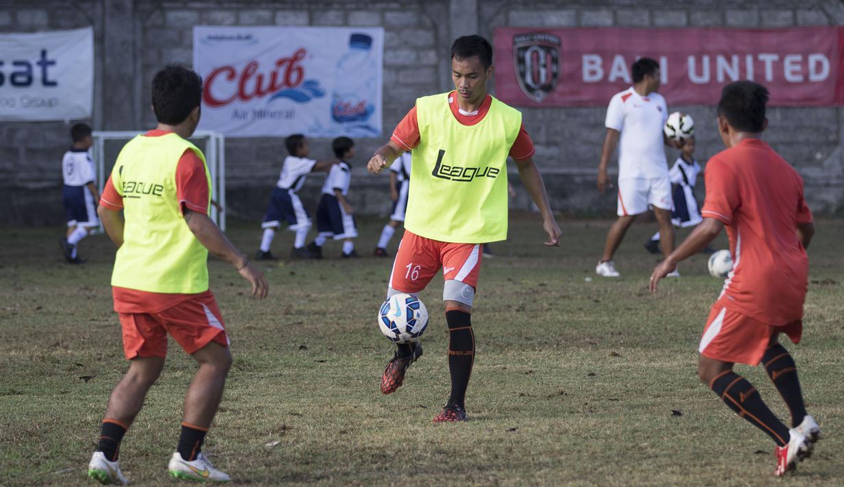 Pemain Persija, Delton Stevano yang sedang latihan jelang laga Piala Presiden melawan Persita harus berbagi lapangan dengan anak-anak SD yang sedang berolahraga di Lapangan Trisakti, Bali, Rabu (2/9/2015). (Bola.com/Vitalis Yogi Trisna) 
