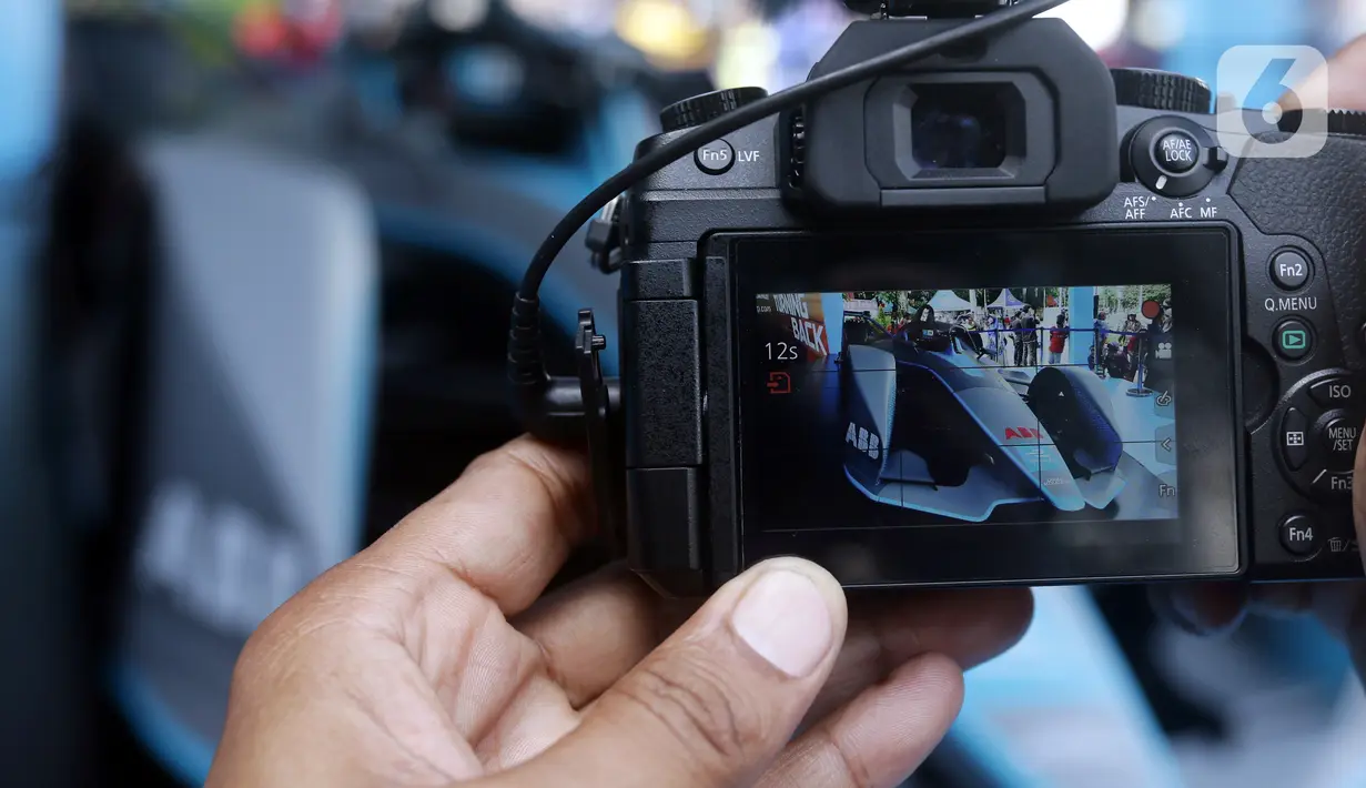 Warga merekam replika mobil Formula E yang dipamerkan di Kawasan Bundaran Hotel Indonesia, Jakarta, Minggu (29/5/2022). Replika mobil balap ramah lingkungan ini dipamerkan untuk mengkampanyekan perhelatan Formula E yang akan digelar 4 Juni mendatang. (Liputan6.com/Helmi Fithriansyah)