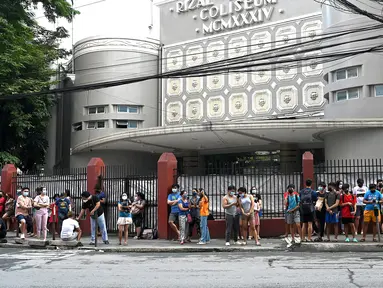 Warga menyelamatkan diri dengan keluar bangunan setelah gempa berkekuatan magnitudo 7,1 terasa di Manila, Filipina, Rabu (27/7/2022). Pusat gempa sekitar 300 kilometer jauhnya dari Manila. (JAM STA ROSA/AFP)