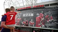 Seorang fans cilik MU sedang melihat stadion Old Trafford yang siap menyambut musim ini (AFP)