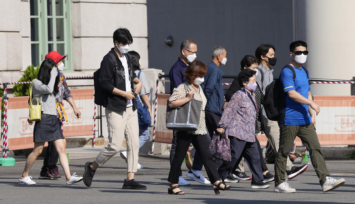 Orang-orang yang berjalan di luar sebuah stasiun di Seoul, Korea Selatan, Jumat (24/9/2021). Korea Selatan telah melaporkan lonjakan harian terbesar virus corona sejak dimulainya pandemi. (AP Photo/Lee Jin-man)