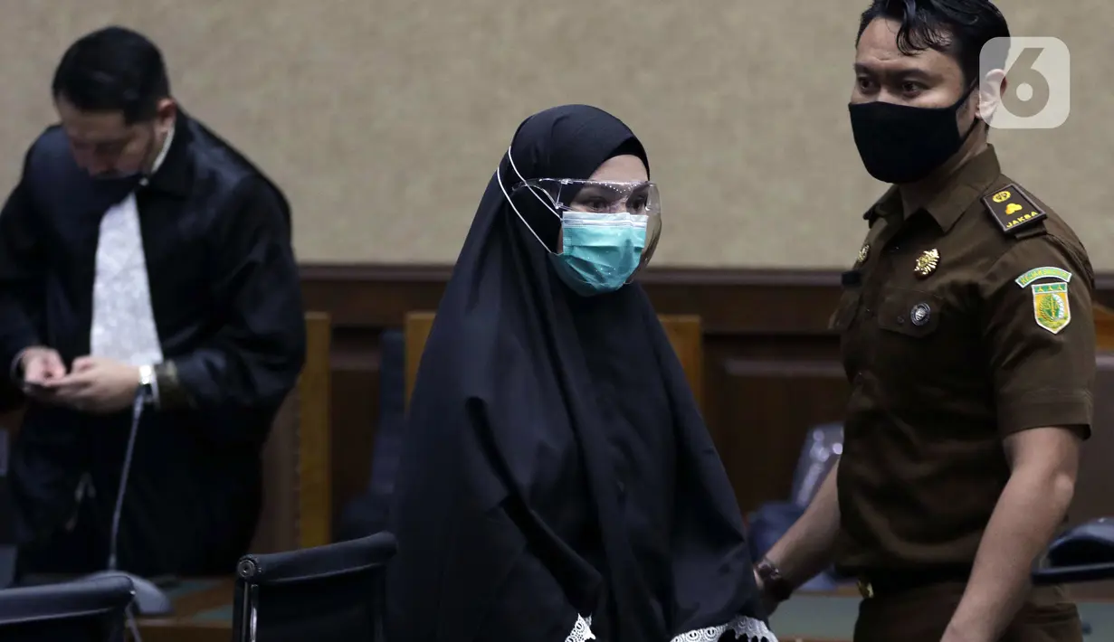 Terdakwa suap dan TPPU terkait pengurusan fatwa Mahkamah Agung untuk Djoko S Tjandra, Pinangki Sirna Malasari (tengah) saat jeda sidang pembacaan putusan di Pengadilan Tipikor Jakarta, Senin (8/2/2021). Sebelumnya, Pinangki dituntut hukuman empat tahun penjara. (Liputan6.com/Helmi Fithriansyah)