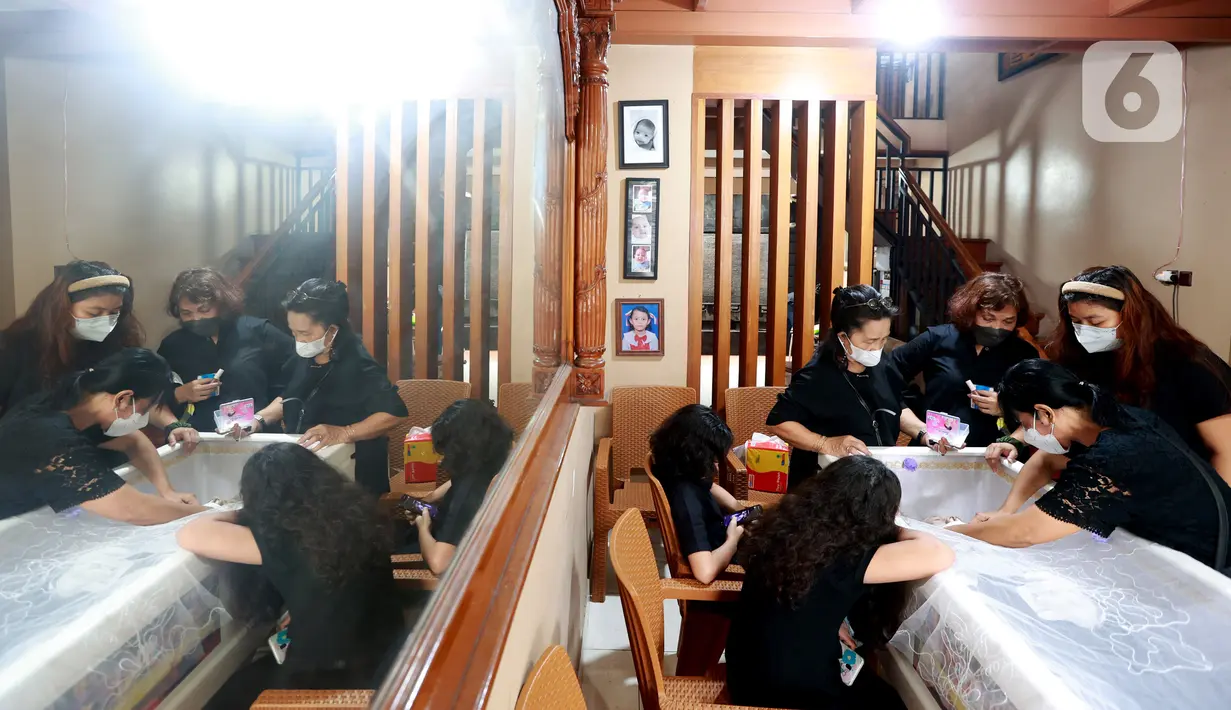 Pelayat berdiri di samping peti jenazah mantan pelatih Tim Nasional Indonesia, Benny Dollo saat disemayamkan di rumah duka kawasan Pamulang, Tangerang Selatan, Kamis (2/2/2023). Mantan pelatih Arema FC dan Persita Tangerang tersebut meninggalkan satu orang istri, dua anak, dan dua cucu. (Bola.com/Muhammad Iqbal Ichsan)