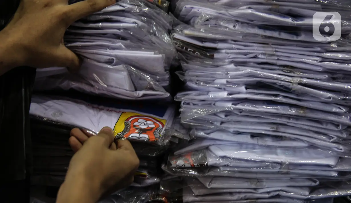 Penjual melihat seragam sekolah dagangannya di kawasan Pasar Jatinegara, Jakarta, Selasa (30/6/2020). Sejumlah pedagang di tempat itu mengeluhkan omset penjualan seragam sekolah yang menurun hingga 90 persen akibat sepi pembeli dan anjuran belajar di rumah saat COVID-19. (Liputan6.com/Faizal Fanani)
