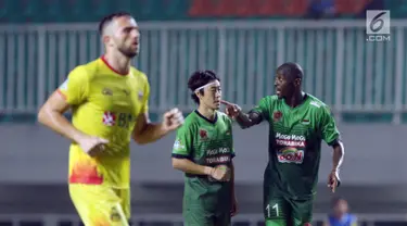 Pemain baru PS TNI, Franklin Anzite Touadere (kanan) berbincang dengan Soonhak Hong saat laga melawan Bhayangkara FC di lanjutan Liga 1 Indonesia, Stadion Pakansari, Kab Bogor, Minggu (3/9). (Liputan6.com/Helmi Fithriansyah)