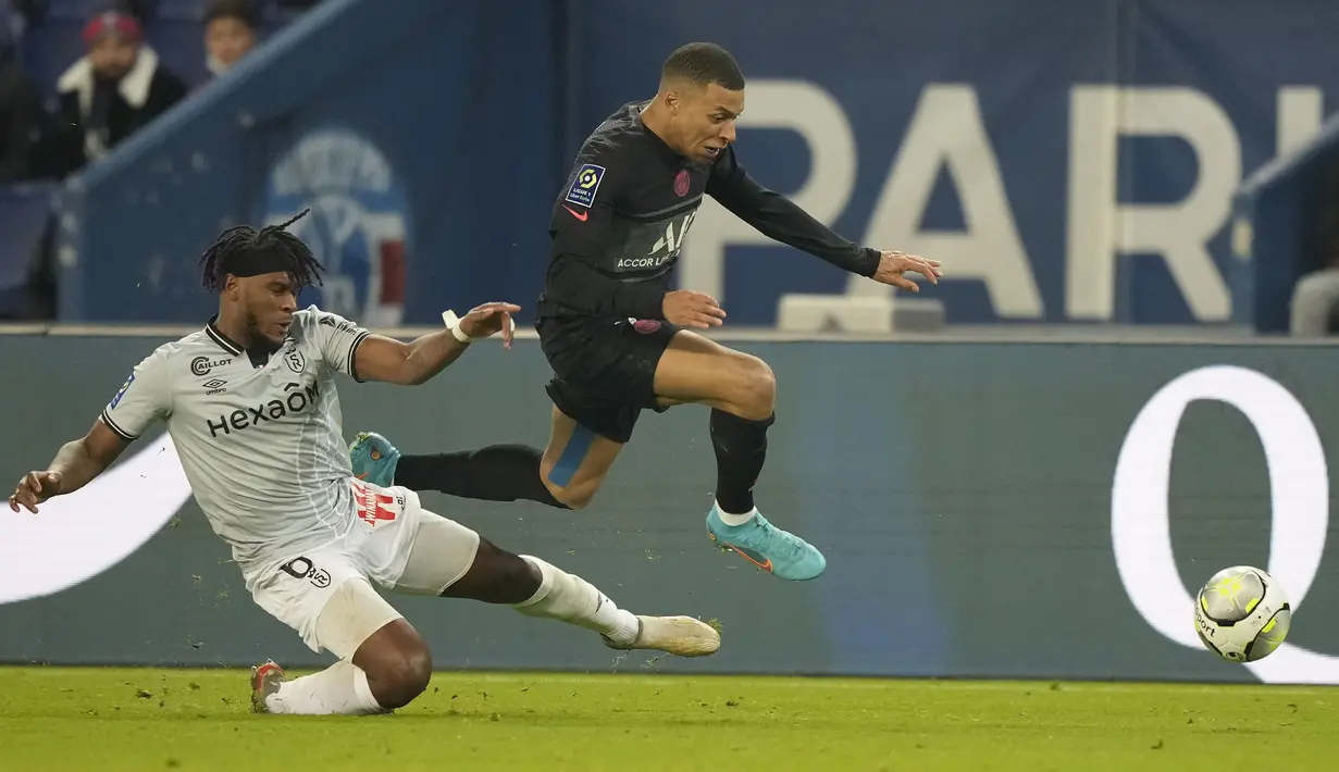 Penyerang Paris Saint-Germain (PSG) Kylian Mbappe melepaskan diri dari bek Reims Yunis Abdelhamid dalam matchday ke-22 Liga Prancis 2021/2022 di Parc des Princes, Senin (24/1/2022) dini hari WIB. PSG menang telak 4-0 atas Reims. (AP Photo/Francois Mori)