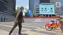 Warga berjalan dekat proyek pembangunan Tugu Sepeda di  kawasan Jenderal Sudirman, Jakarta, Rabu (22/9/2021). Dinas Perhubungan DKI Jakarta memastikan pembangunan Tugu Sepeda masih berlanjut, dan pembangunnya hingga saat ini telah mencapai 90 persen. (Liputan6.com/Herman Zakharia)
