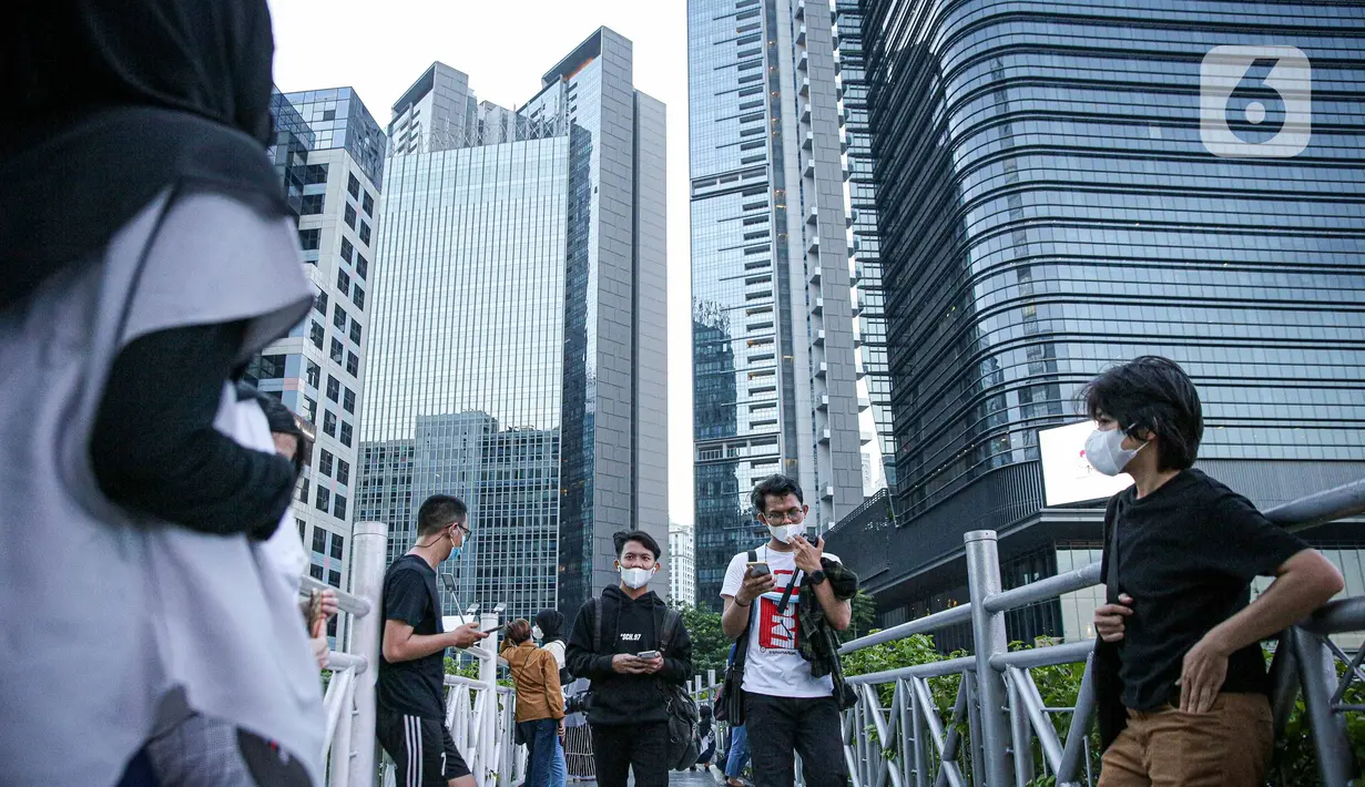Warga berkumpul diatas JPO tanpa atap di Jakarta, Minggu (12/9/2021). Kasus baru positif Covid-19 di Indonesia per Minggu (12/9) bertambah sebanyak 3.779 kasus Jumlah tersebut membuat total kasus virus corona sejak awal pandemi mencapai 4.167.511 kasus. (Liputan6.com/Faizal Fanani)