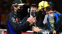 Luca Marini (kanan) mendapat sambutan dari sang kakak, Valentino Rossi ketika finis tiga besar pada salah satu balapan Moto2 2020. (LLUIS GENE / AFP)