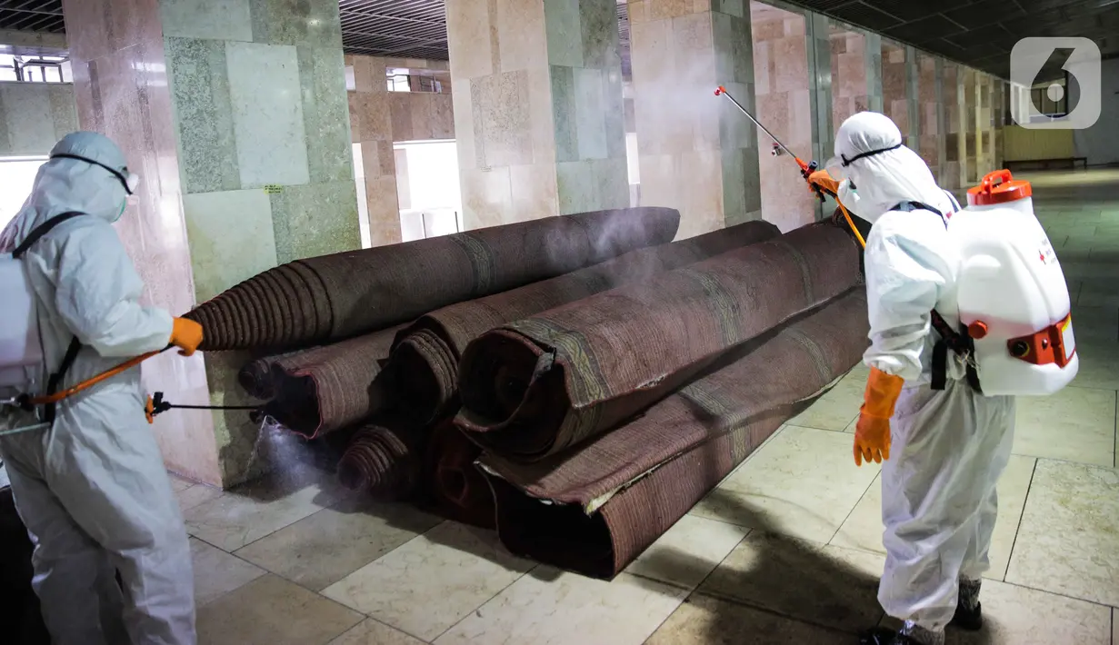 Petugas menyemprotkan cairan disinfektan ke karpet yang digunakan Masjid Istiqlal, Jakarta Pusat, Jumat (13/3/2020). Pembersihan oleh petugas gabungan tersebut untuk mencegah penyebaran virus corona COVID-19 di lingkungan Masjid Istiqlal. (Liputan6.com/Faizal Fanani)