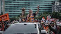 Ketua PP The Jakmania Ferry Indrasjarief membawa Piala Presiden yang diraih oleh Persija Jakarta pada pawai kemenangan di kawasan Sudirman, Minggu (18/2). Tak ada pengalihan arus di sepanjang jalur konvoi Persija dan Jakmania. (Liputan6.com/Faizal Fanani)